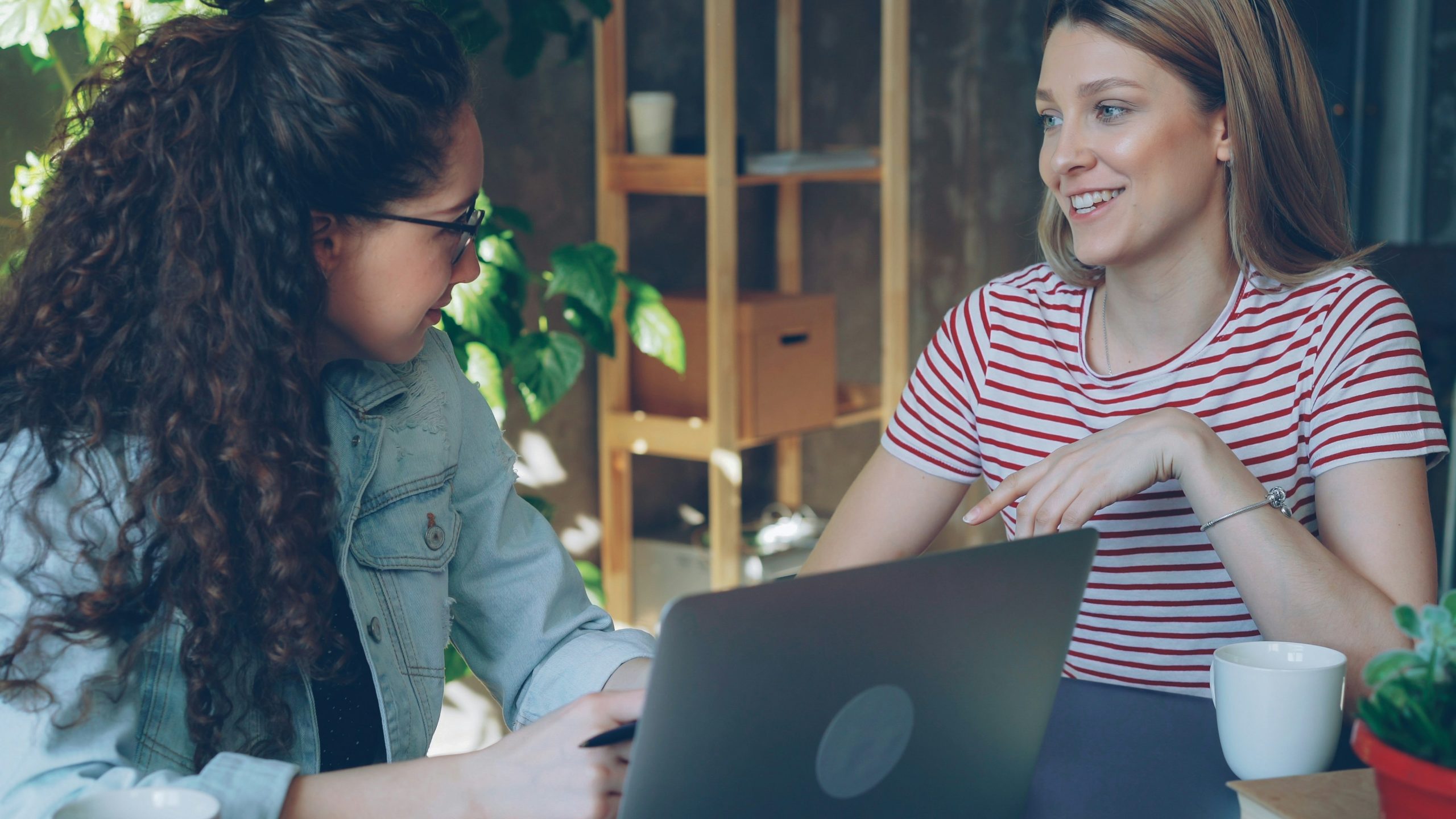 Two women working together on a laptop